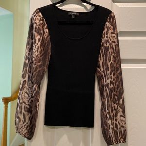 Inc black knit top with animal print sleeves.